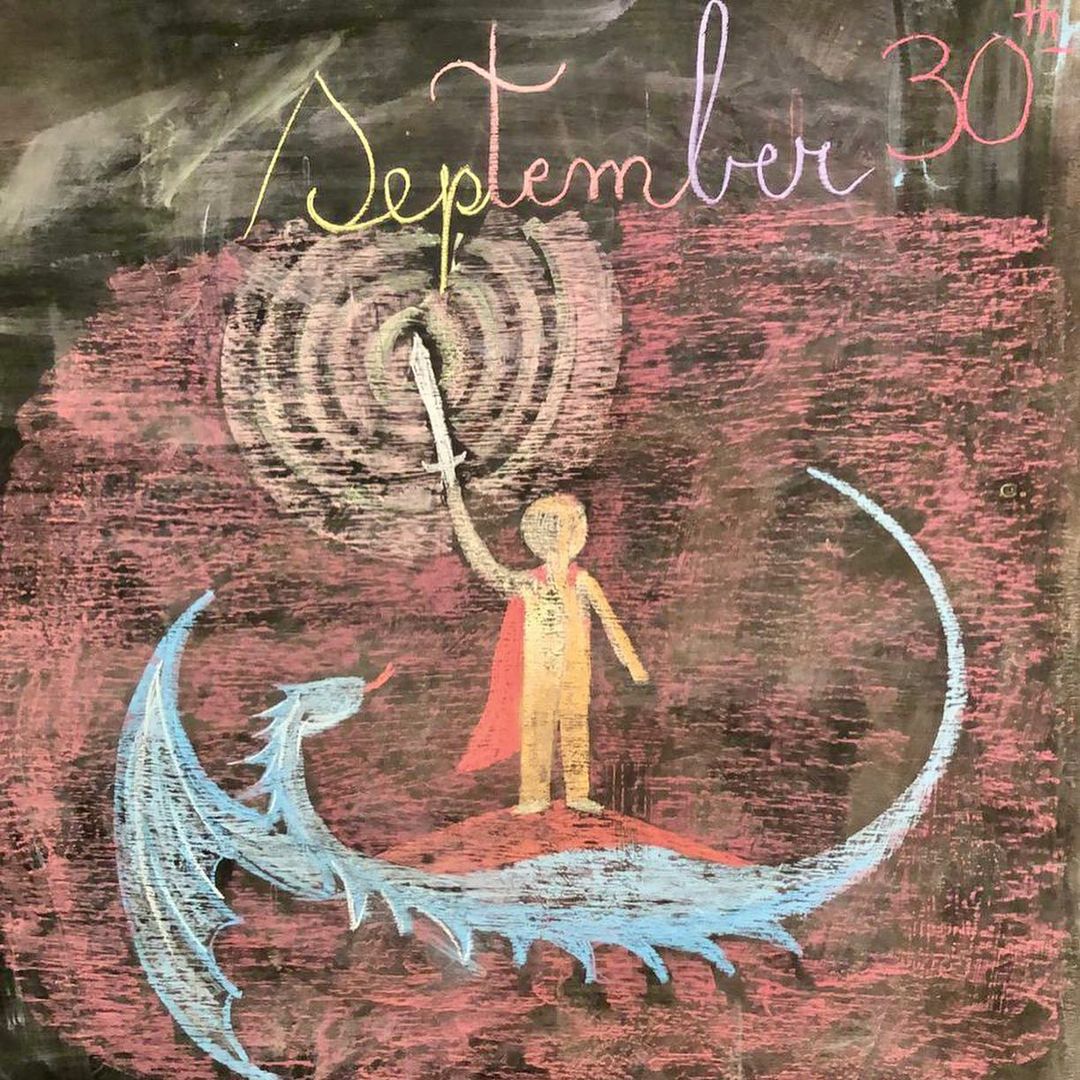 Dibujo en tiza de un dragón en la pizarra de la sala