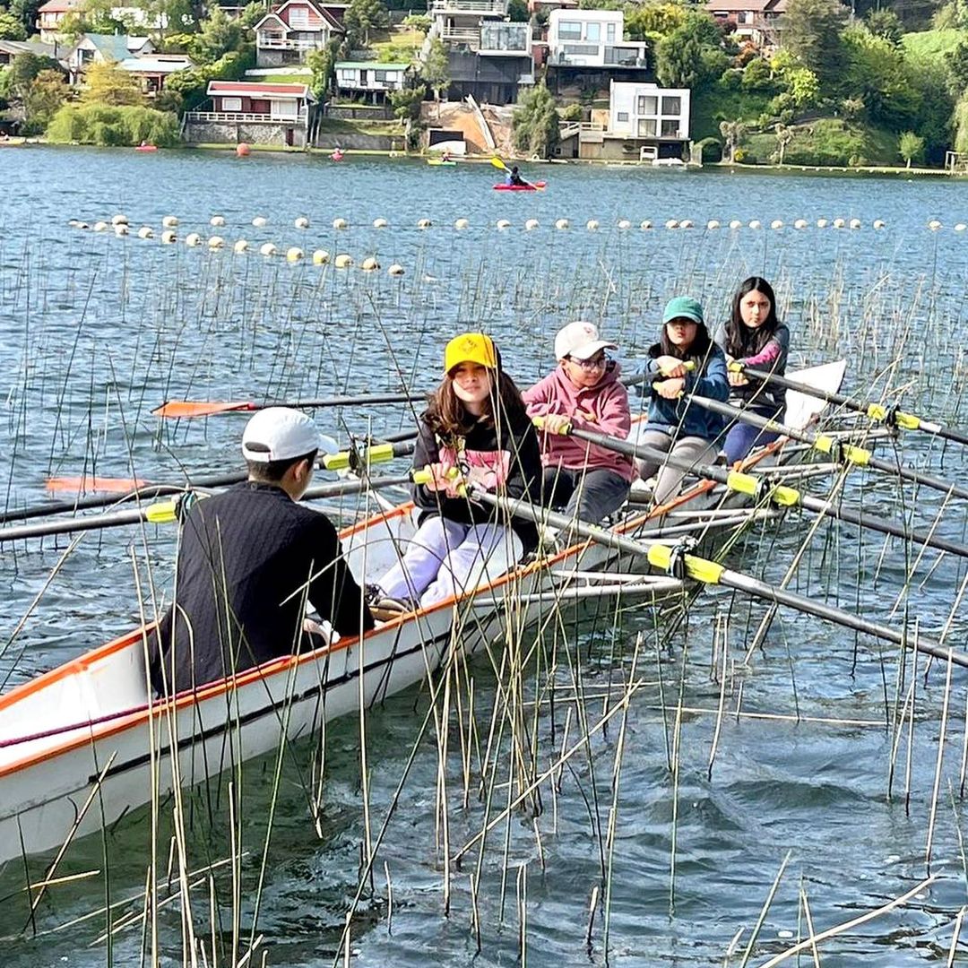 Estudiantes remando en un bote sobre el lago